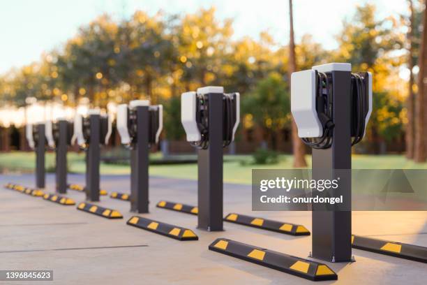 electric car charging station in outdoor parking lot - parking space imagens e fotografias de stock