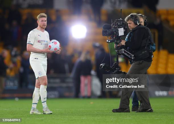 Kevin De Bruyne of Manchester City is filmed by a tv camera as he carries the match ball after scoring a hat-trick during the Premier League match...