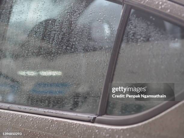 rainy season,  rain falling on the glass,rain drops on the car's side mirror window background - mirror steam stockfoto's en -beelden