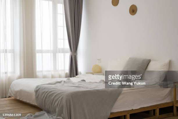 a bed in apartment - empty bedroom stock-fotos und bilder