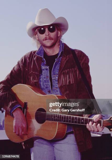 American Country musician Alan Jackson plays an acoustic guitar during the filming of a music video, for his song 'Gone Country' , on a midtown...