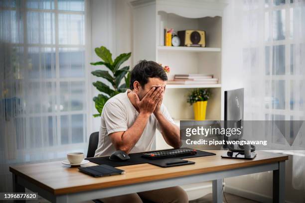 businessman sitting with hands covering his face, he is stressed from work to do. even when working at home while doing social distancing instead. - hålla huvudet i händerna bildbanksfoton och bilder
