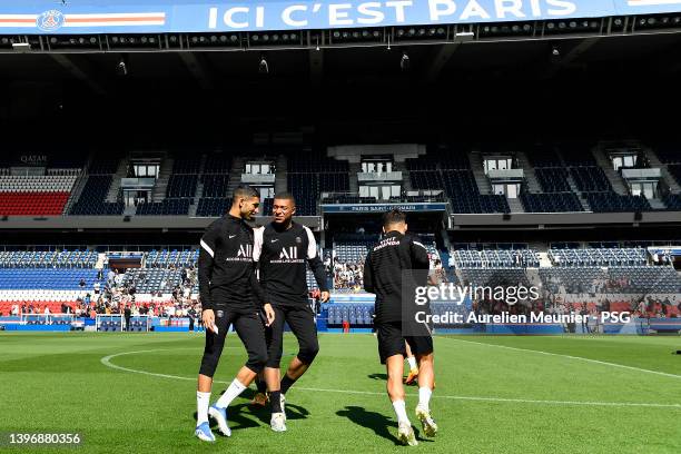 Kylian Mbappe speaks with Achraf Hakimi during a Paris Saint-Germain training session at Parc des Princes on May 12, 2022 in Paris, France.