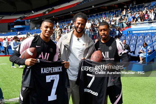 Colin Kaerpernick poses with Kylian Mbappe and Presnel Kimpembe as he attrends a Paris Saint-Germain training session at Parc des Princes on May 12,...