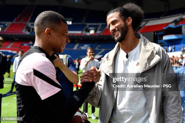 Colin Kaerpernick checks with Kylian Mbappe as he attends a Paris Saint-Germain training session at Parc des Princes on May 12, 2022 in Paris, France.