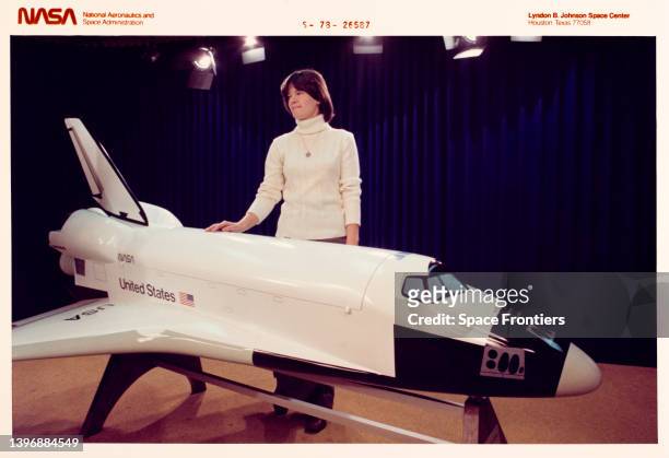 American astronaut and physicist Sally Ride stands by the Space Shuttle orbiter model in the small briefing room in Building 2 at the Johnson Space...