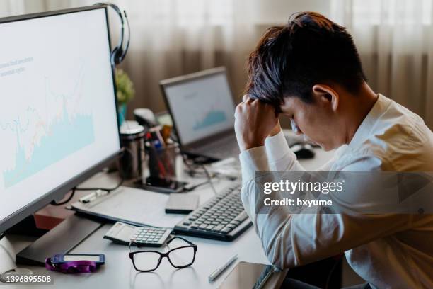 hombre de negocios con exceso de trabajo que se siente cansado en la oficina - distressed stock market people fotografías e imágenes de stock