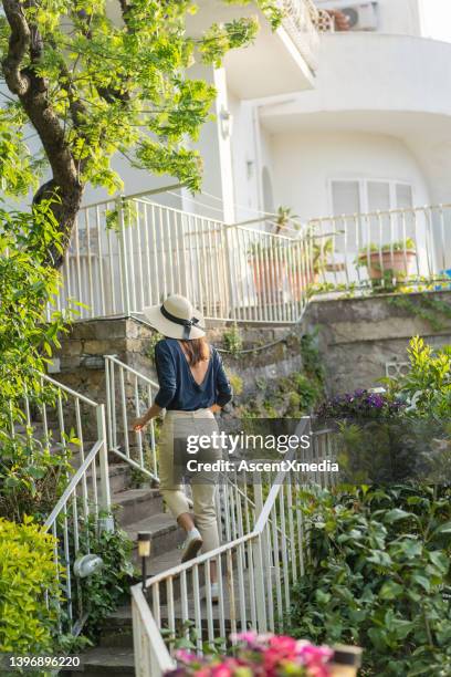 young woman relaxes in lush backyard - lush backyard stock pictures, royalty-free photos & images