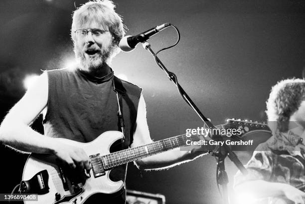 View of American Rock and Blues musicians Trey Anastasio , on guitar, and Mike Gordon , on bass, both of the group Phish, as they perform on stage at...