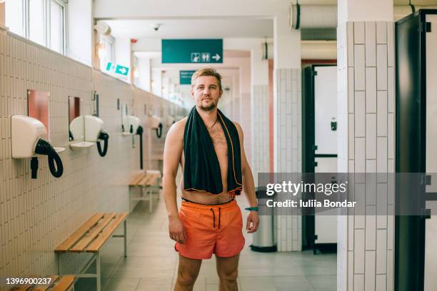 young man in the pool changing room - buitenbad stockfoto's en -beelden