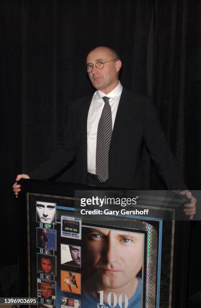 Portrait of British Pop musician Phil Collins as he poses with an award plaque during City of Hope's 'Spirit of Life' gala at Cipriani, New York, New...