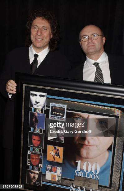 Portrait of Atlantic Records CEO and Co-Chairman Val Azzoli and Pop musician Phil Collins as the latter is present with an award plaque during City...