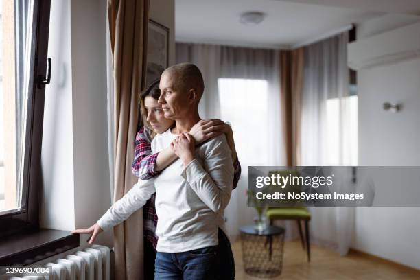 woman with cancer and her daughter - sick window stockfoto's en -beelden