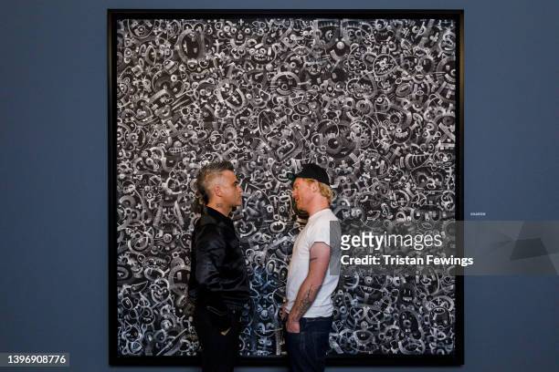 Robbie Williams and Ed Godrich attend the launch event for the Williams Godrich exhibition at Sotheby's on May 12, 2022 in London, England.