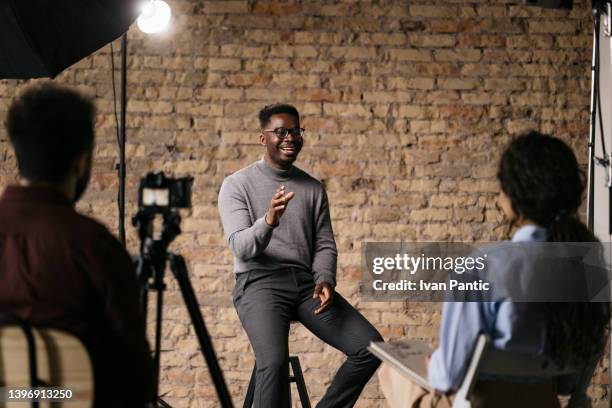 donner une interview dans un studio modeste - interview photos et images de collection