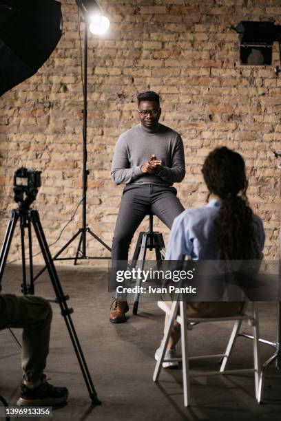 giving an interview in a modest studio - diverse film set stock pictures, royalty-free photos & images