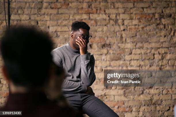 difficulty controlling emotions during an interview. man crying during the interview - people speaking great background stock pictures, royalty-free photos & images