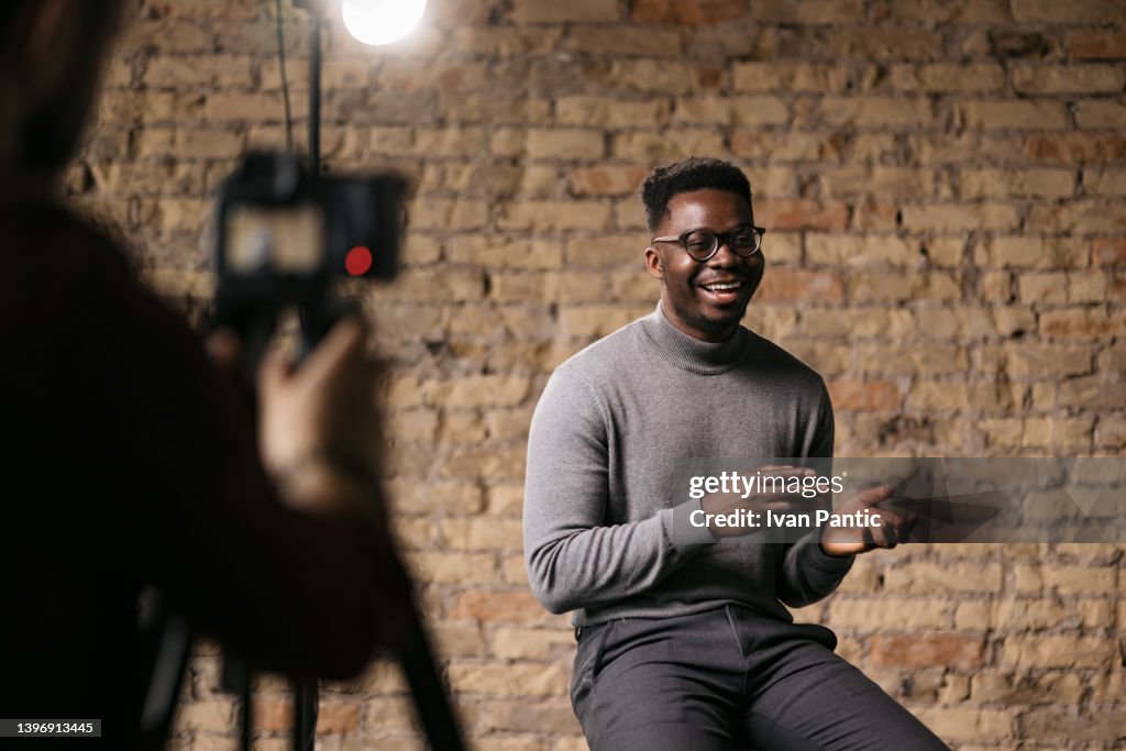 Junger Mann gibt ein Interview in einem Studio