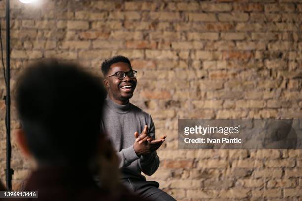 junger mann gibt ein interview in einem studio - african american interview stock-fotos und bilder