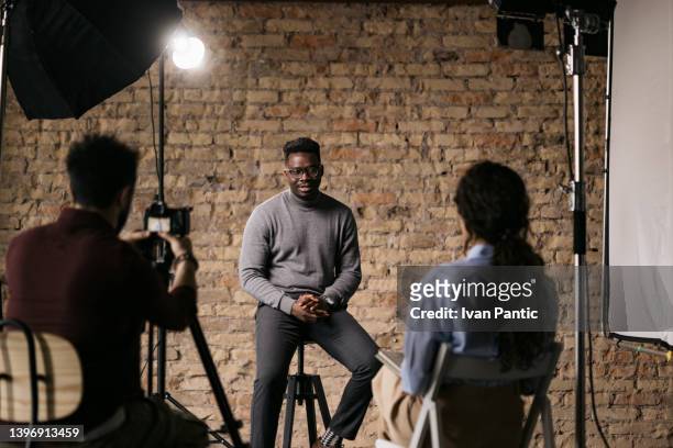 giving an interview in a modest studio - diverse film set stock pictures, royalty-free photos & images