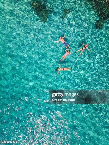 aerial view of a young family floating and swimming on beautiful beach at greek island - thasos 個照片及圖片檔