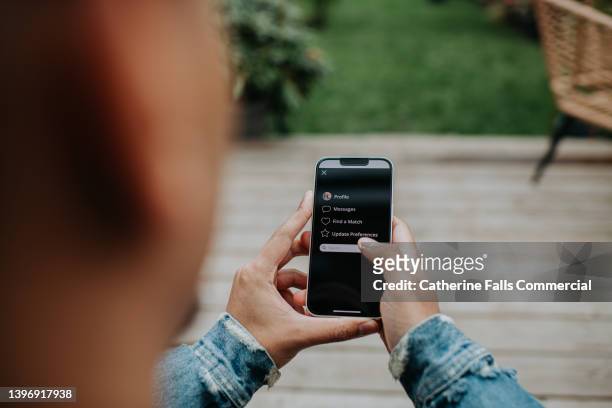 a man holds a smart phone and browses a dating app with a simple user-friendly interface - voice search stock pictures, royalty-free photos & images