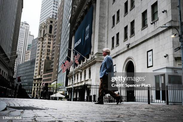 People walk by the New York Stock Exchange on May 12, 2022 in New York City. Prices of clothing, food, gas and cars are just a few of the items that...