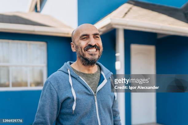 hombre feliz frente a su nueva casa - candidat fotografías e imágenes de stock