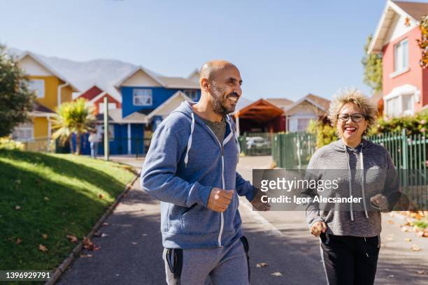 couple jogging in the neighborhood - financial freedom stock pictures, royalty-free photos & images