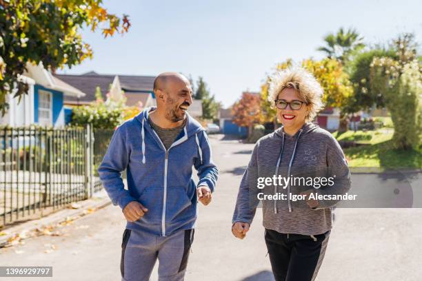 couple jogging in the neighborhood - een dag uit het leven serie stockfoto's en -beelden
