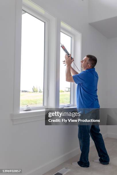 homeowner remodeling home with new energy efficient windows and caulking - caulk stock pictures, royalty-free photos & images