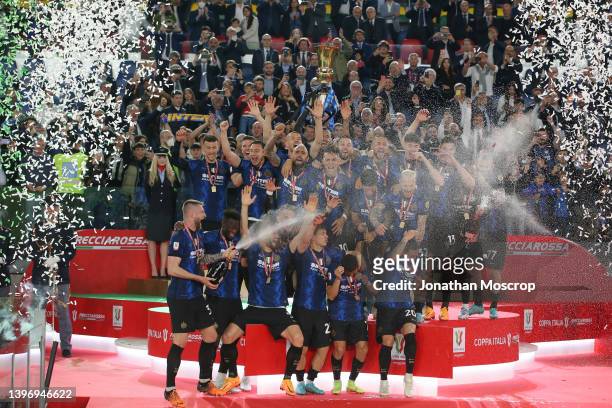 Milan Skriniar of FC Internazionale sprays team mates with champagne as they celebrate with the trophy on the stage following the 4-2 victory in the...