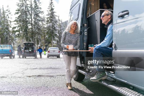 adventurous senior couple enjoying winter vacation in their camper van - motor home winter stock pictures, royalty-free photos & images