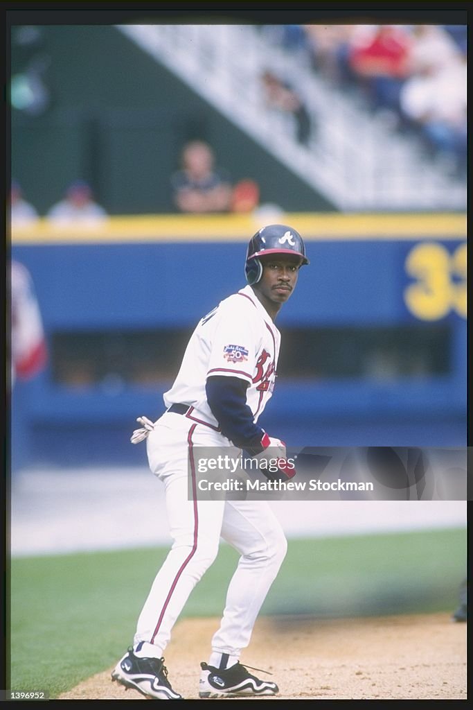 Outfielder Kenny Lofton of the Atlanta Braves leads off a base during ...