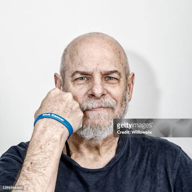 senior man cancer survivor kick cancer wristband - cancer survivor stock pictures, royalty-free photos & images