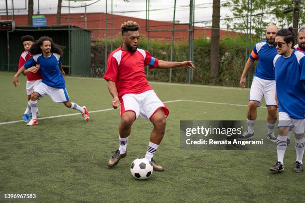 amigos jugando al fútbol el fin de semana - liga de deportes fotografías e imágenes de stock