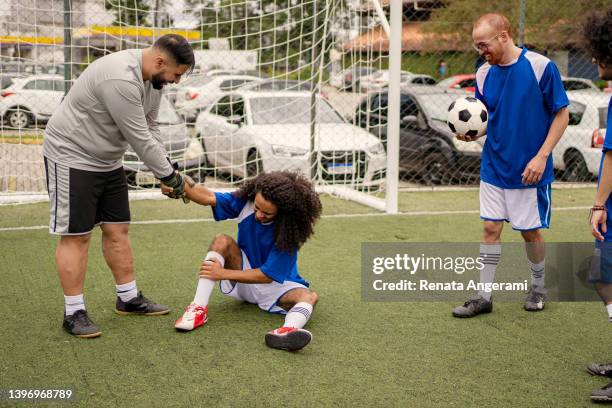 futbolista lesionado en el partido entre amigos - falta término deportivo fotografías e imágenes de stock
