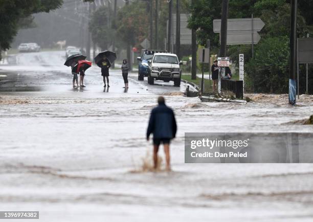 Locals inspect a road cut off by floodwater on May 13, 2022 in Laidley, Australia. Parts of southeast Queensland are on flood watch as the state...