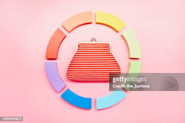 pie chart made of colorful building blocks and wallet on pink background - multi colored purse stock-fotos und bilder