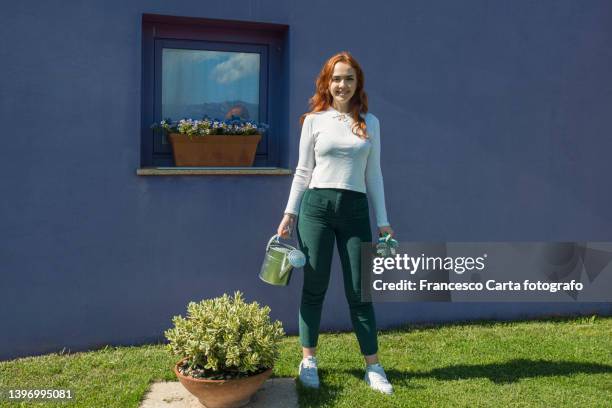 young woman holding watering can in garden - holding watering can stock pictures, royalty-free photos & images