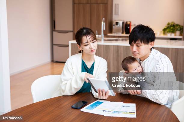 young asian couples discuss financial planning together at home. - save our future babies stock pictures, royalty-free photos & images