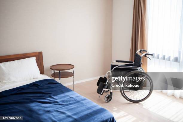 空の車椅子と部屋のベッド - 介護施設 ストックフォトと画像