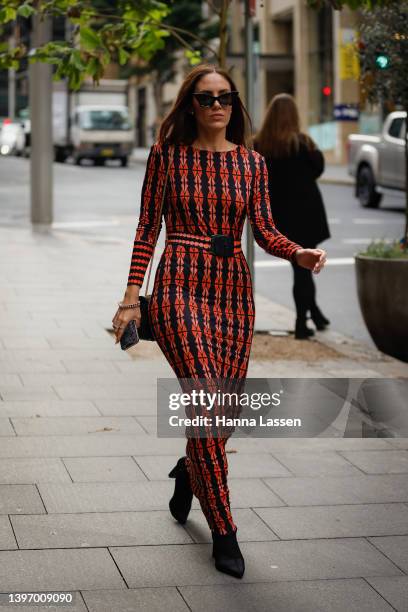 Guest wearing a red and black pattern maxi dress and a sunglasses at Afterpay Australian Fashion Week 2022 on May 13, 2022 in Sydney, Australia.