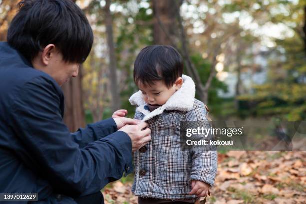 father and son spending the afternoon in the park - rolwisseling stockfoto's en -beelden