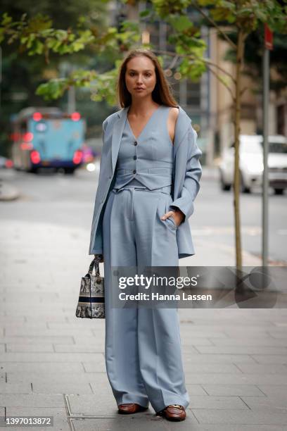 Guest wearing blue Henne suit and Christian Dior bag at Afterpay Australian Fashion Week 2022 on May 13, 2022 in Sydney, Australia.