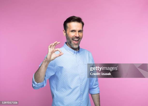 felice uomo mid adult che gesticola il segno ok - ok foto e immagini stock