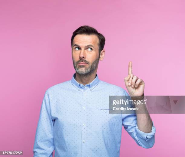 man in shirt pointing upwards - guy pointing stock pictures, royalty-free photos & images