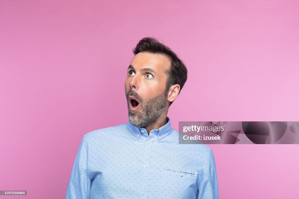 Surpreso homem meio adulto olhando para cima