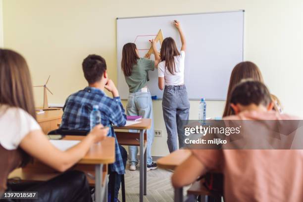 alunni in classe a scuola che svolgono compiti matematici alla lavagna - ruler foto e immagini stock