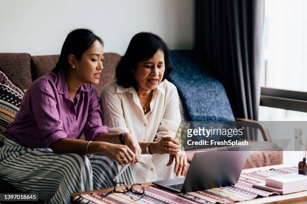 mother and daughter at an online doctor's appointment - adult children with parents stockfoto's en -beelden